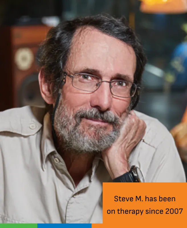 Man smiling and leaning on his hand